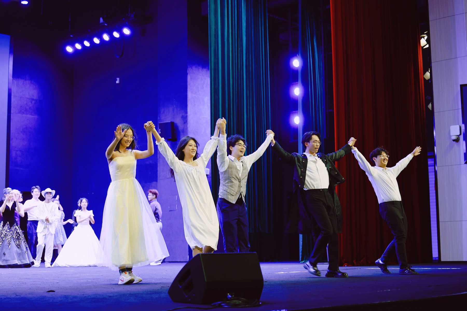 Performers holding hands during a curtain call