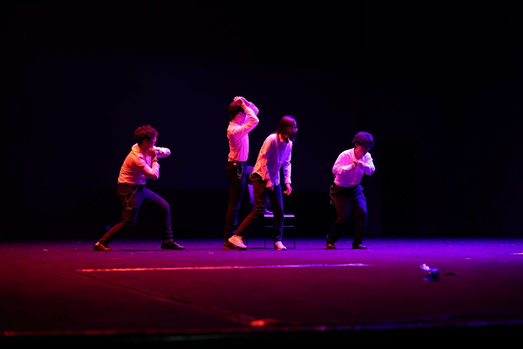 Four performers on a purple-lit stage in a selection from Les Misérables